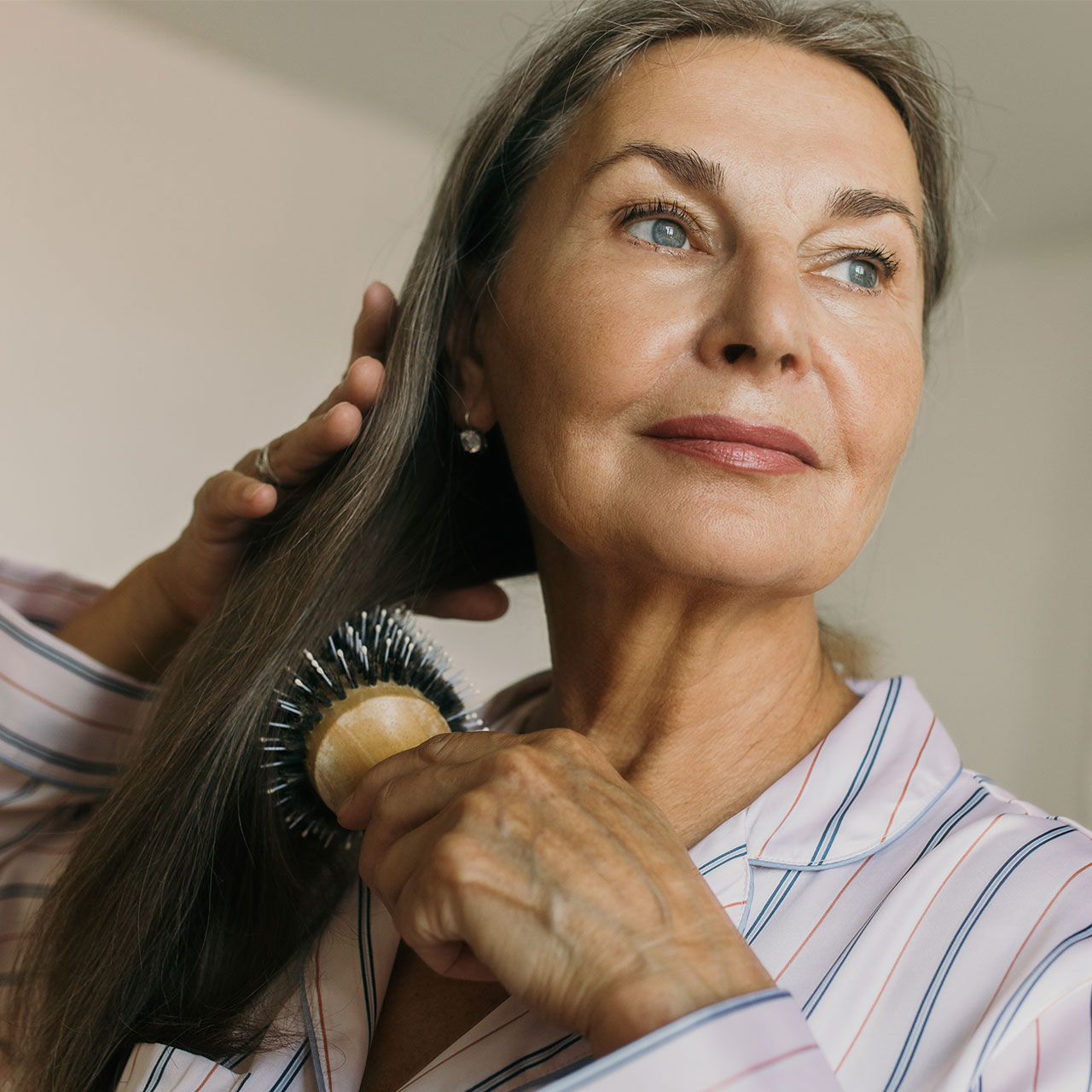 grey-haired-woman-brushing-hair