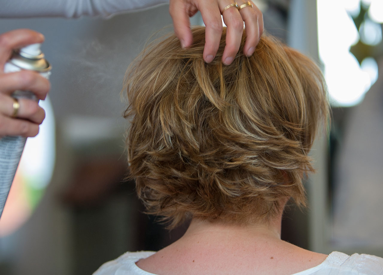 hairstylist-spraying-older-woman-hair