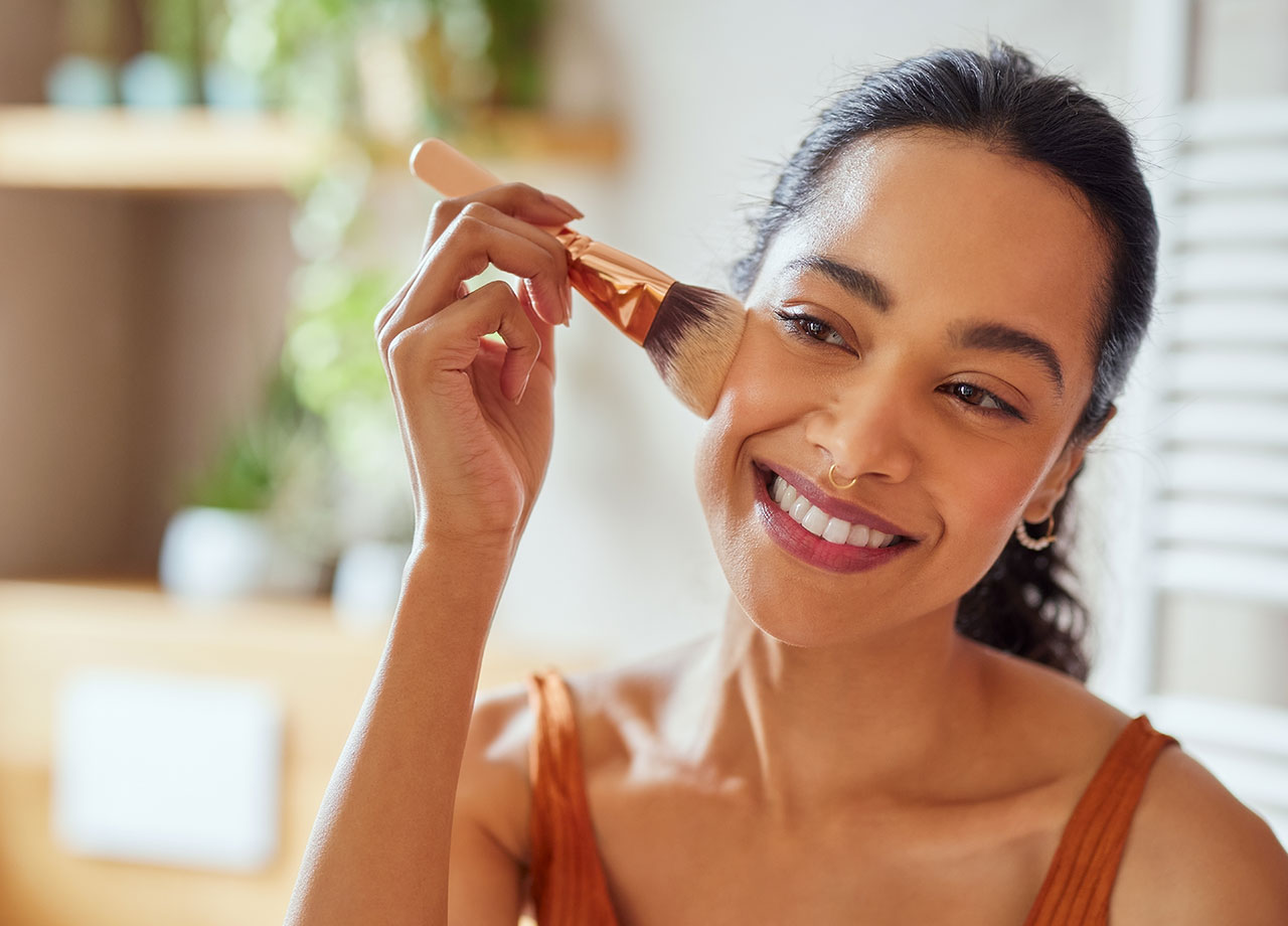 woman-using-brush-apply-makeup