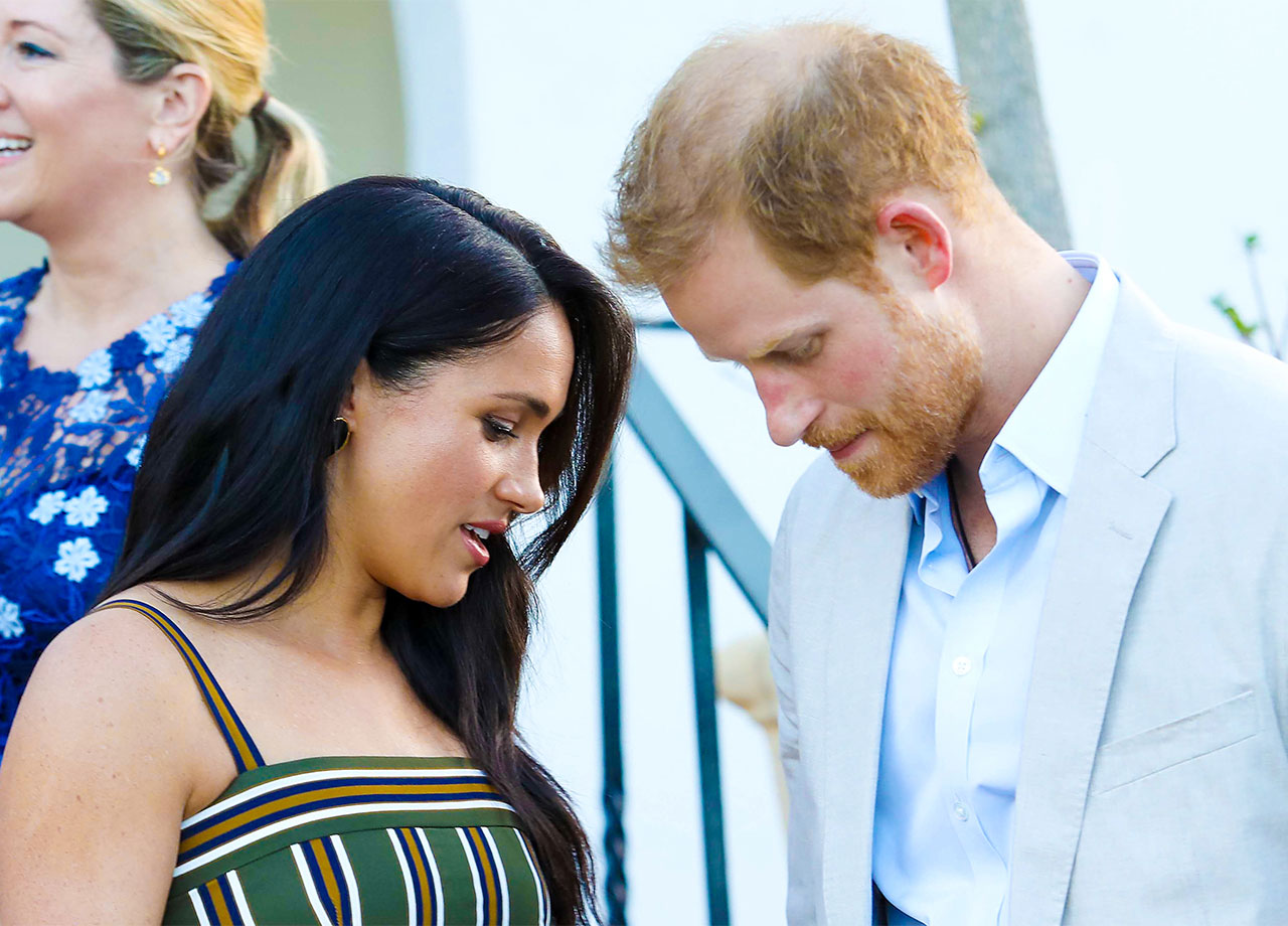 Prince Harry and Meghan Markle bowing their heads