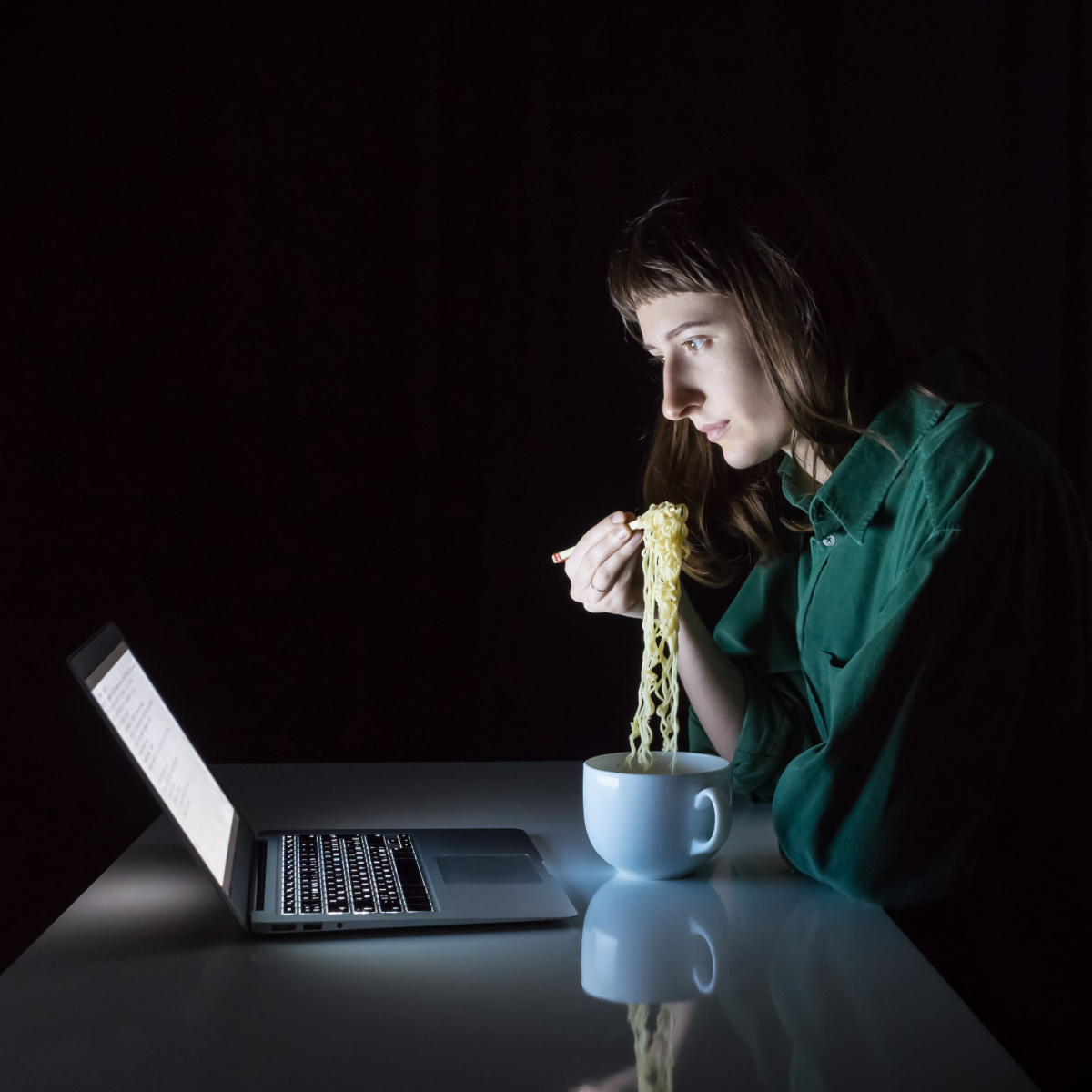 woman eating ramen late at night