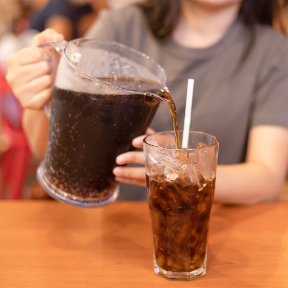 woman pouring soda in glass