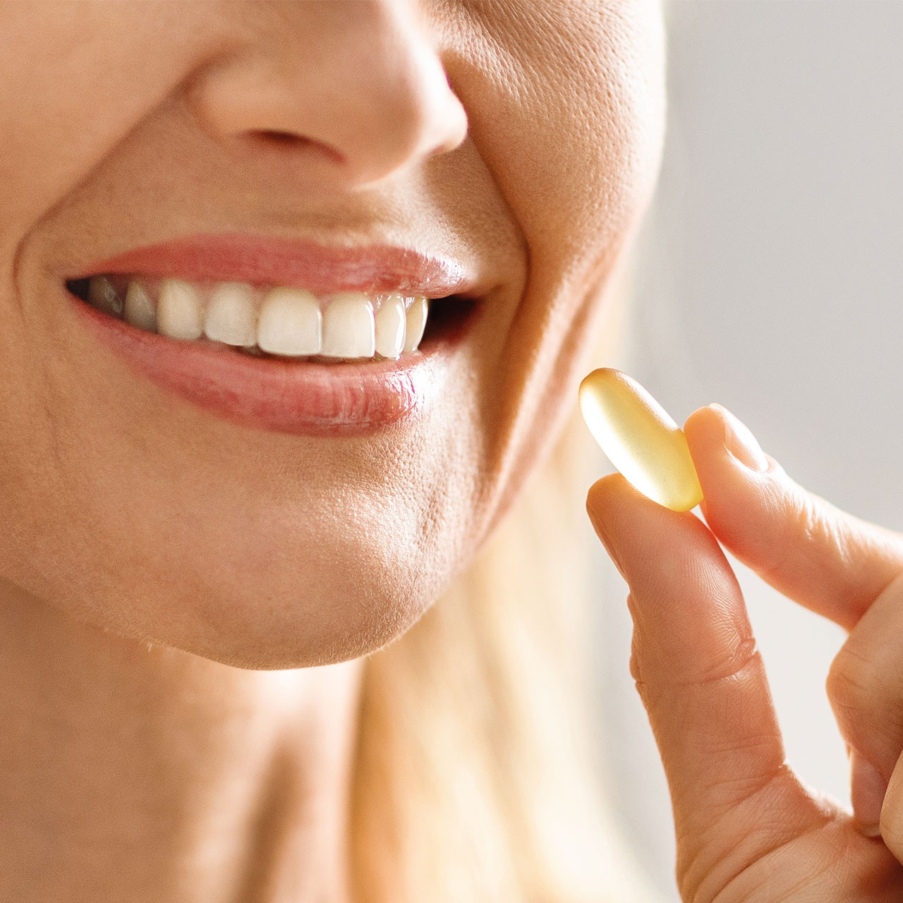 woman-smiling-taking-vitamin