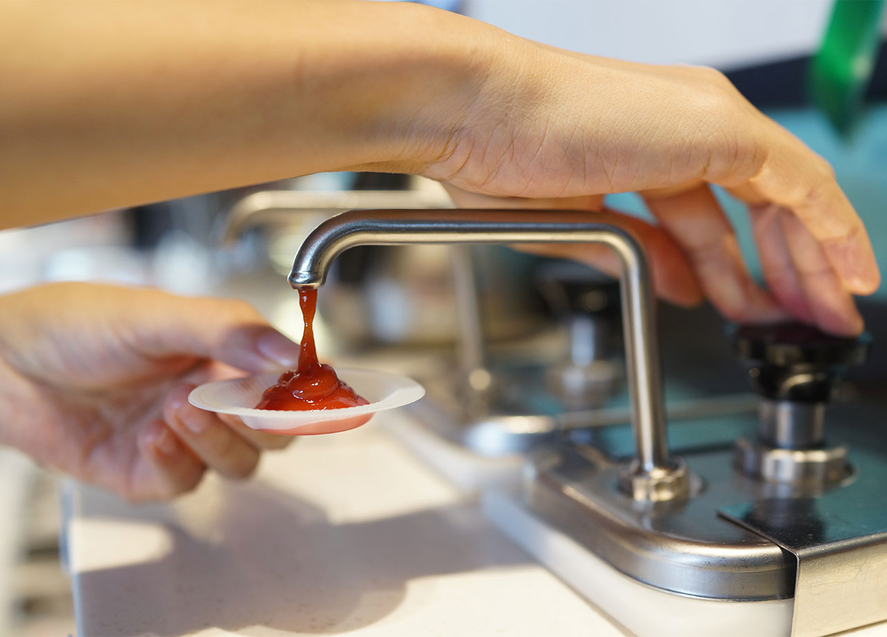 person using ketchup dispensers