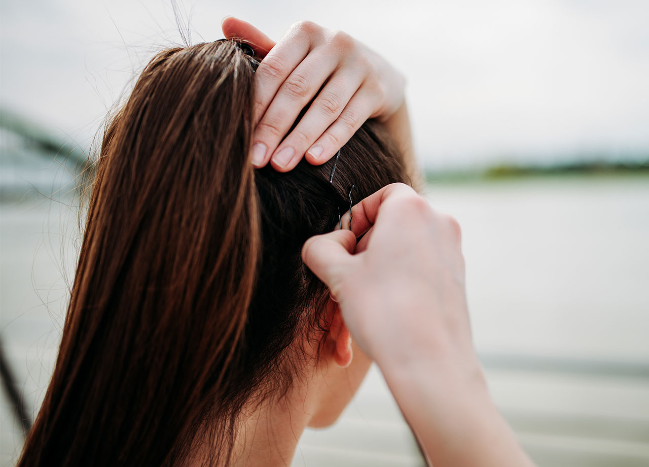 Woman putting her hair into a tight ponytail