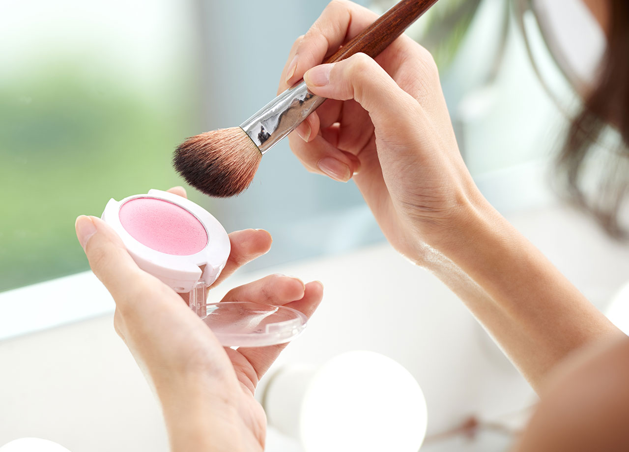 woman using powder blush compact