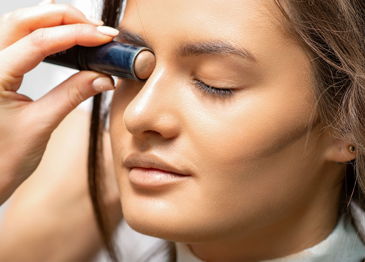 makeup artist contouring a woman's face