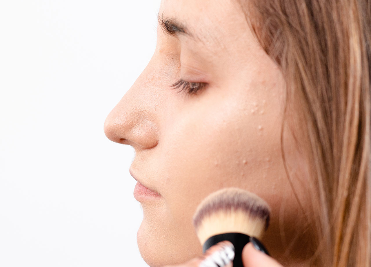 woman applying foundation to textured dry skin