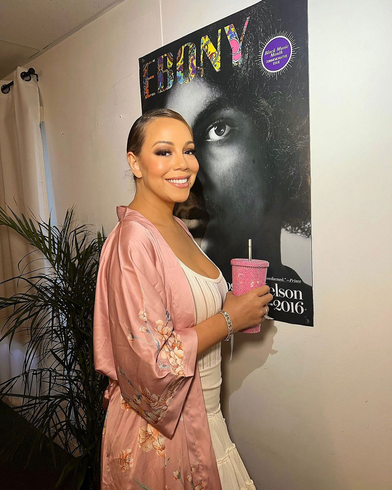 mariah carey in white tank top and pink floral robe on instagram holding pink rhinestone merch tumbler cup