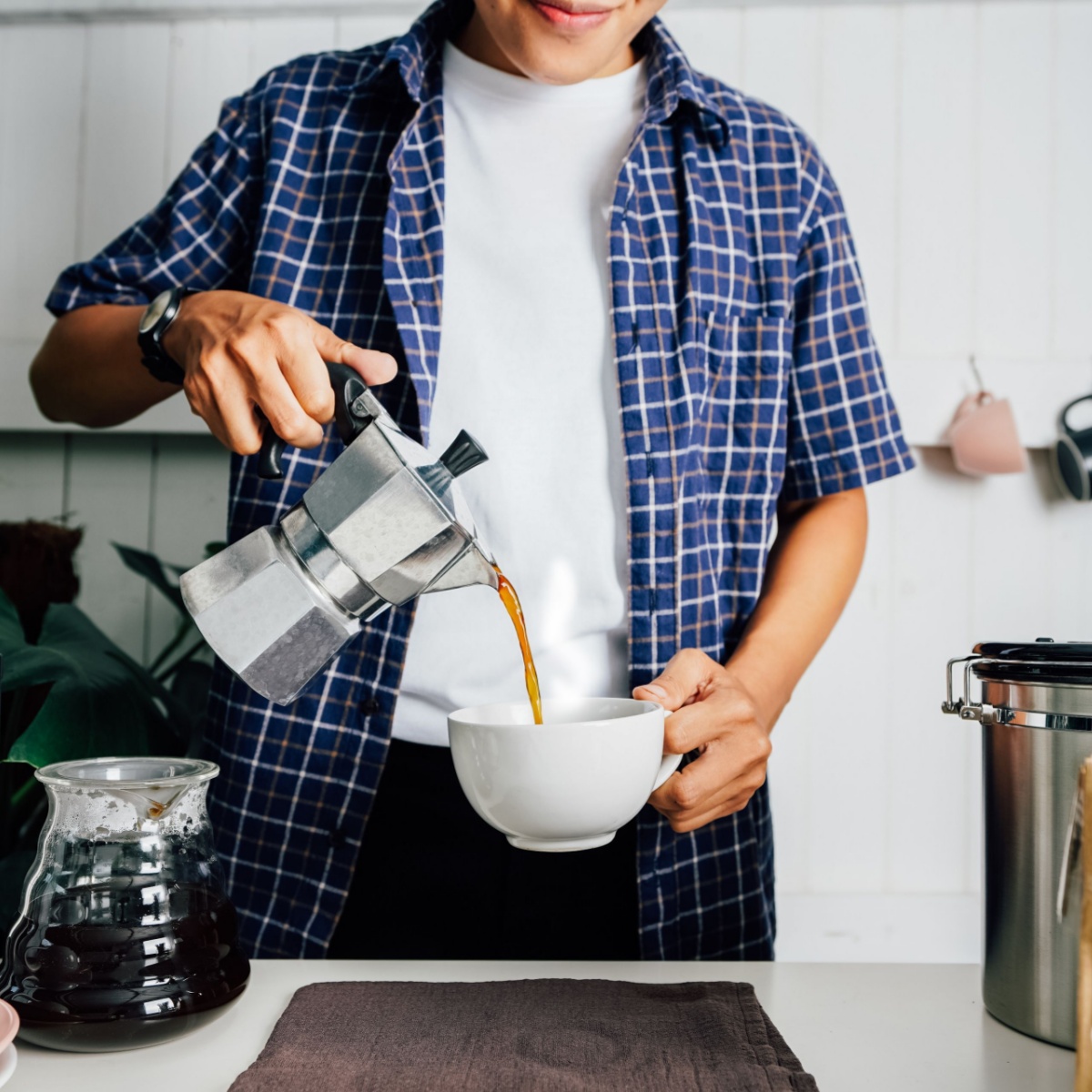 man pouring coffee into cup