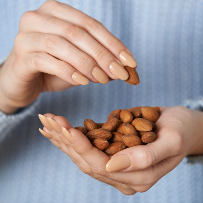 woman eating handful of nuts