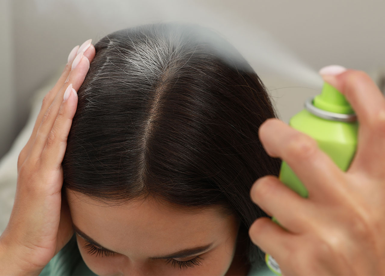 spraying-dry-shampoo-dark-hair