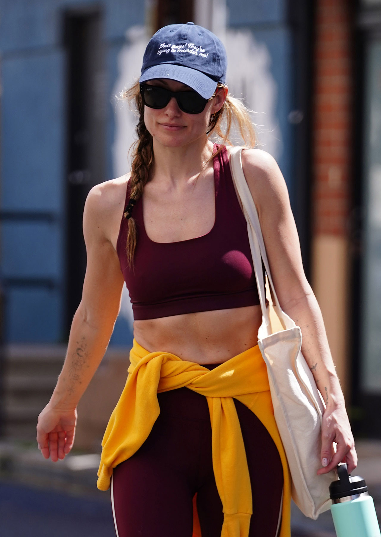 olivia wilde leaving gym in los angeles in maroon workout set with yellow jacket around waist