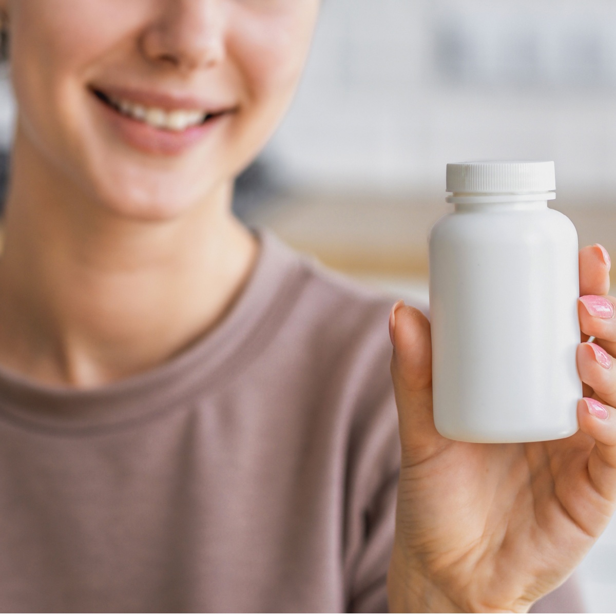 woman holding supplement bottle