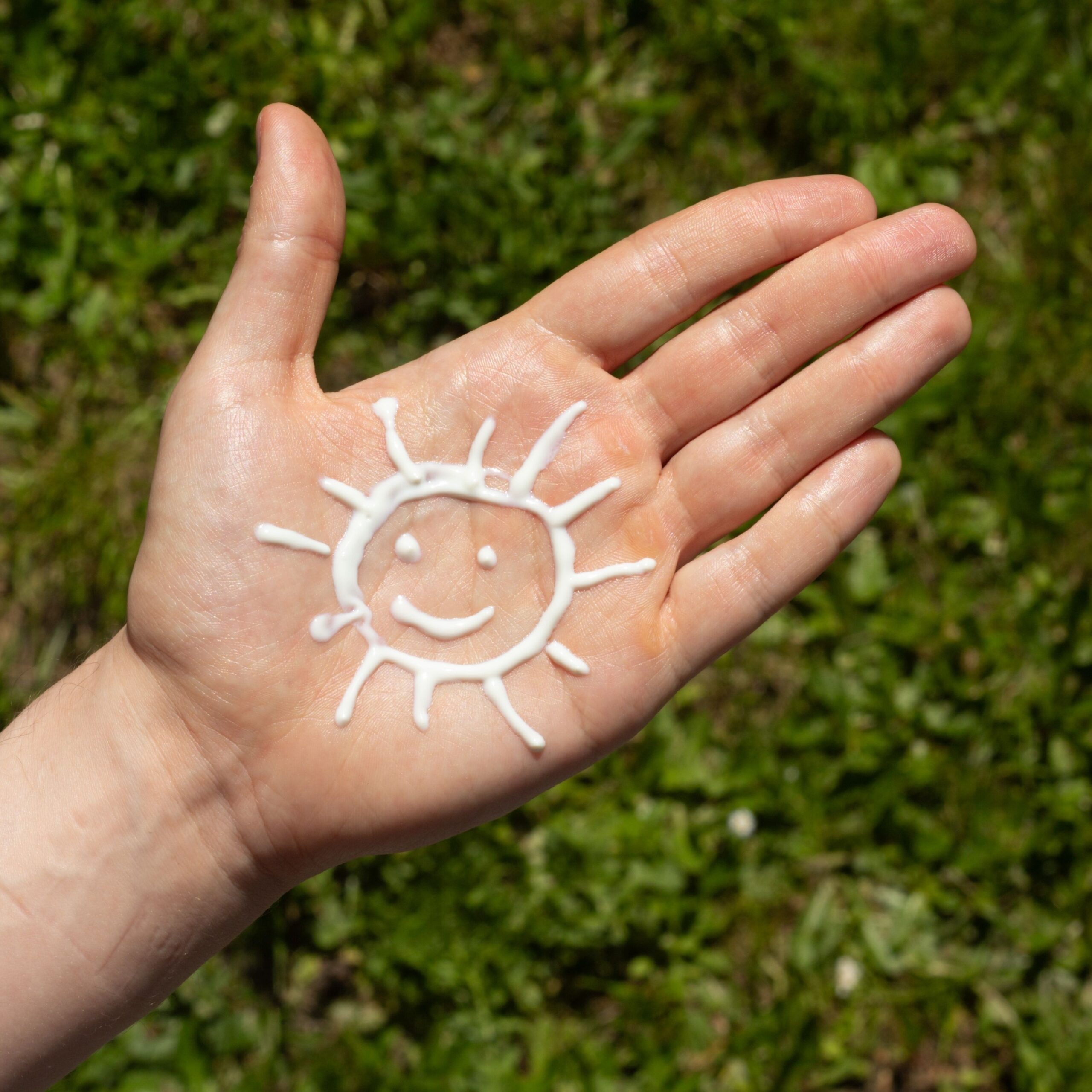 sun drawn in sunscreen on palm of hand