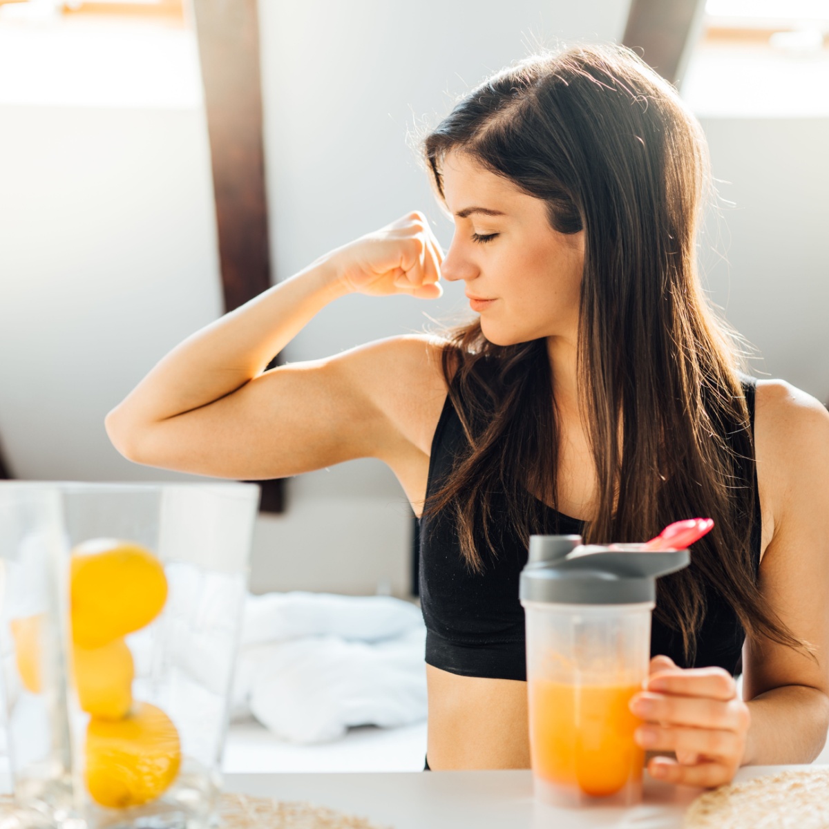 woman flexing muscle and holding a drink