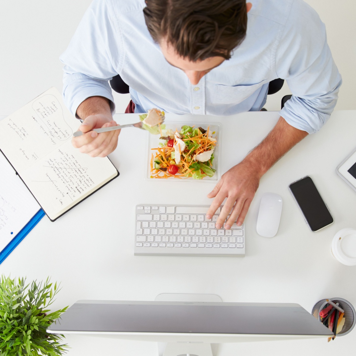 man eating food at his desk