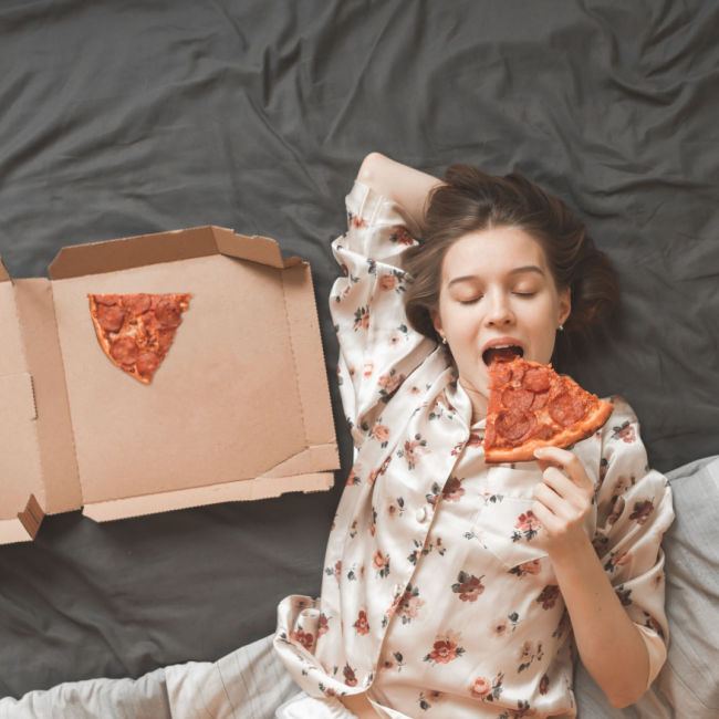 woman eating pepperoni pizza