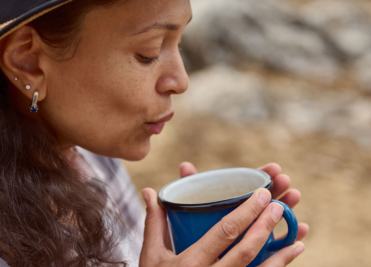 woman sipping a hot cup of coffee or tea