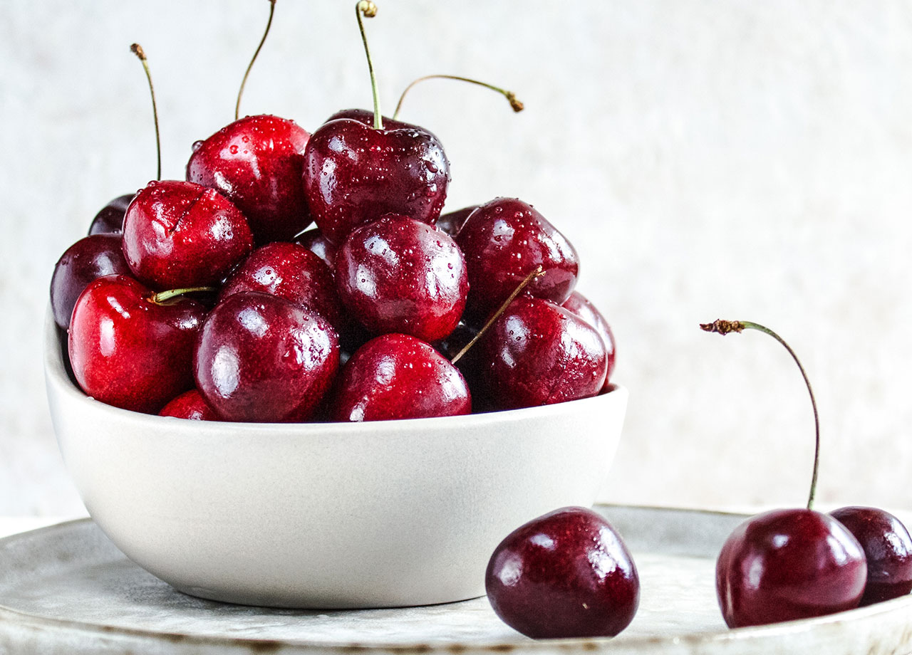 white bowl of cherries