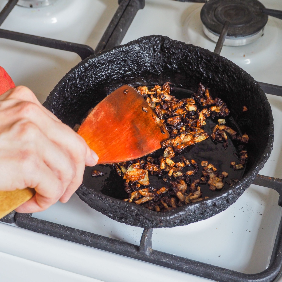 person overcooking onions