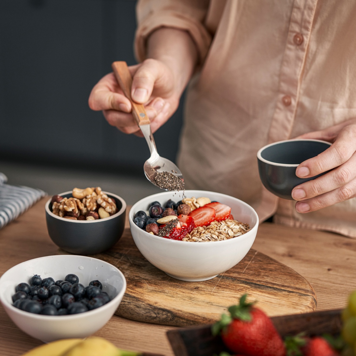 person adding chia seeds to bowl