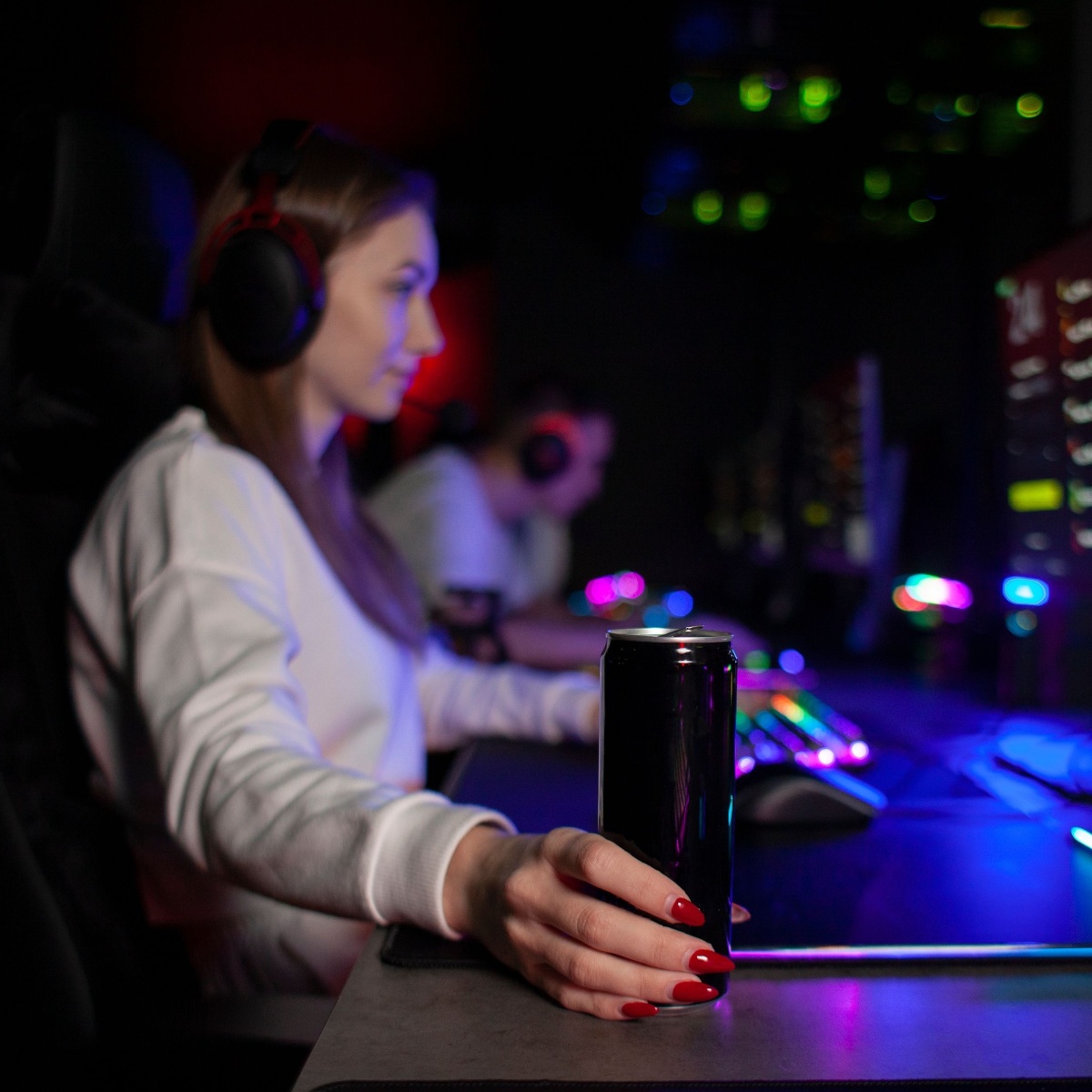 girl holding can of carbonated drink at night