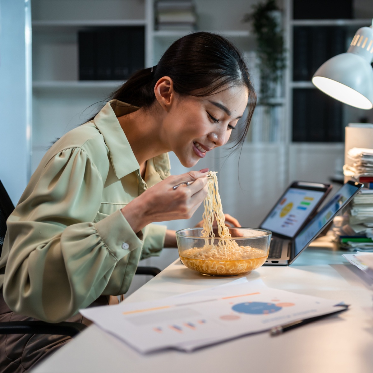 woman eating salty ramen at night