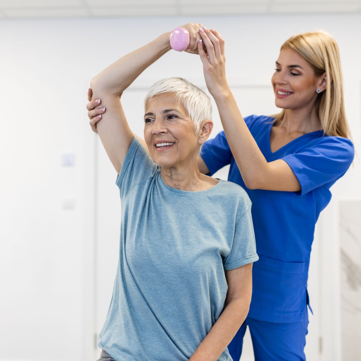 elderly woman lifting her arm with help