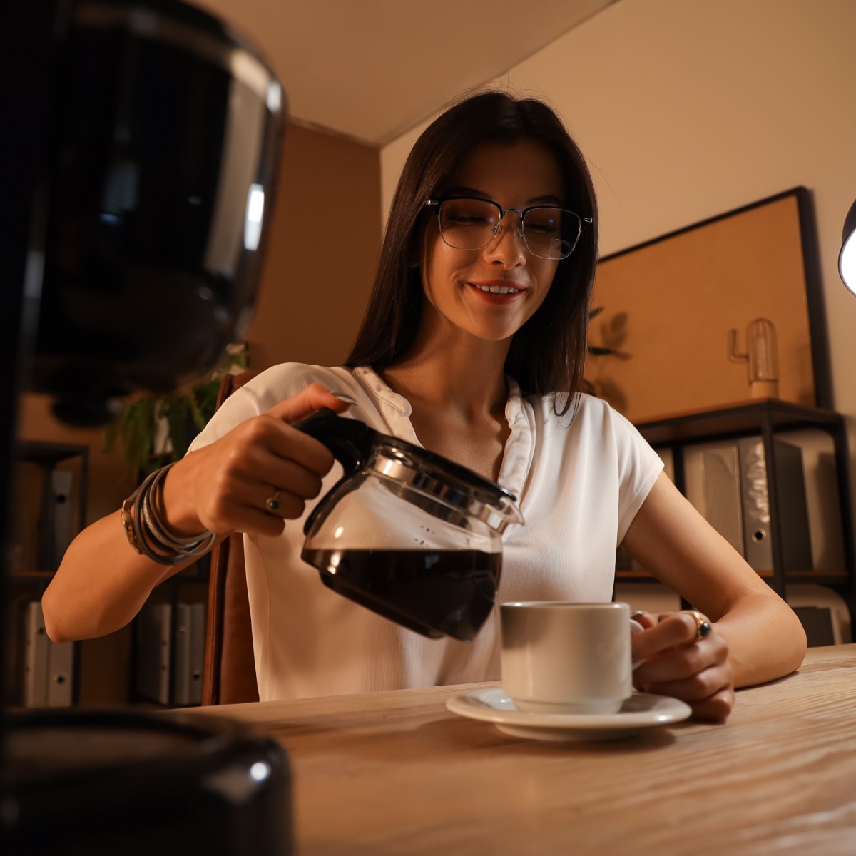 woman pouring coffee at night