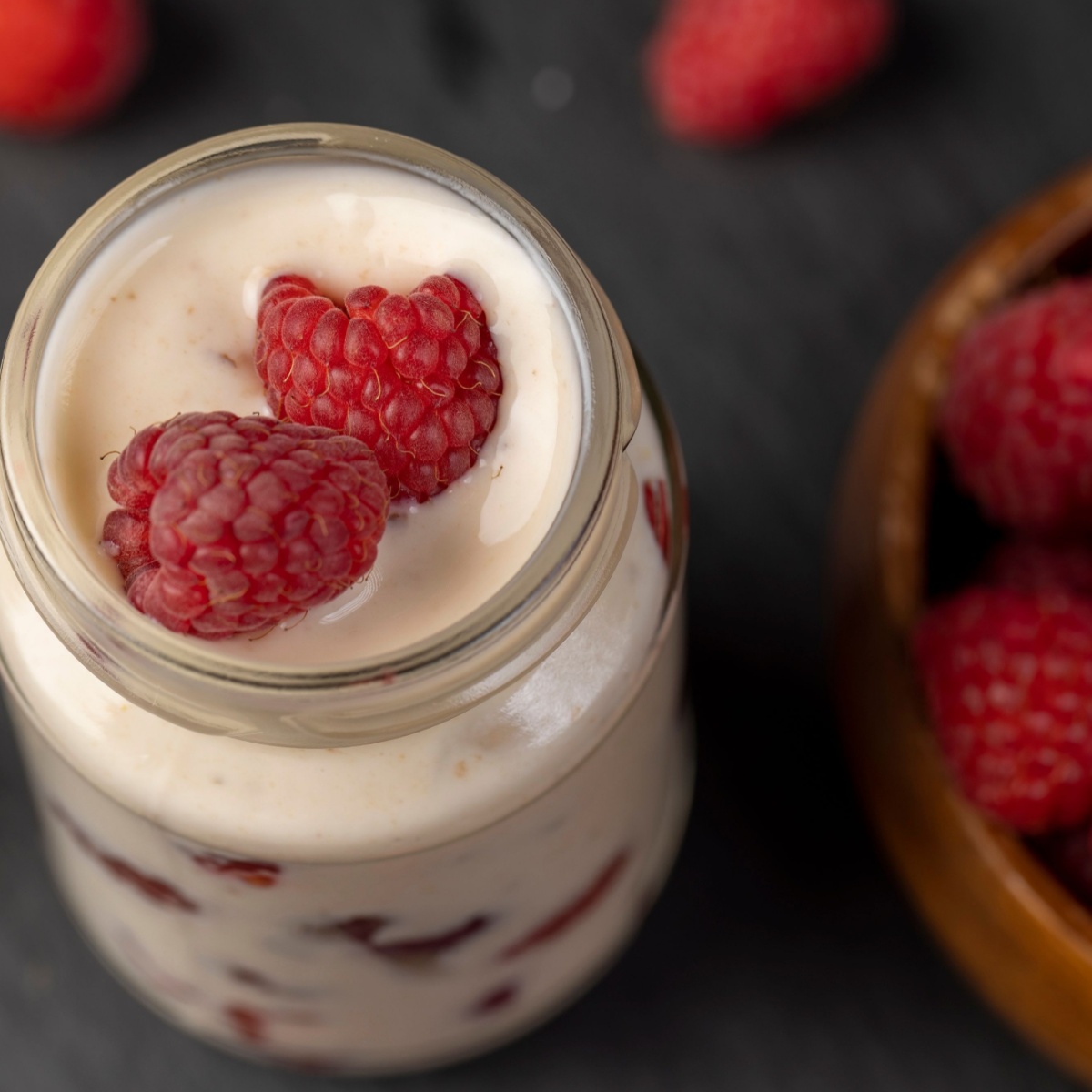 raspberries and cream in a glass jar