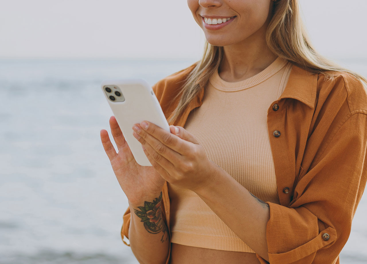 woman-smiling-iphone-beach