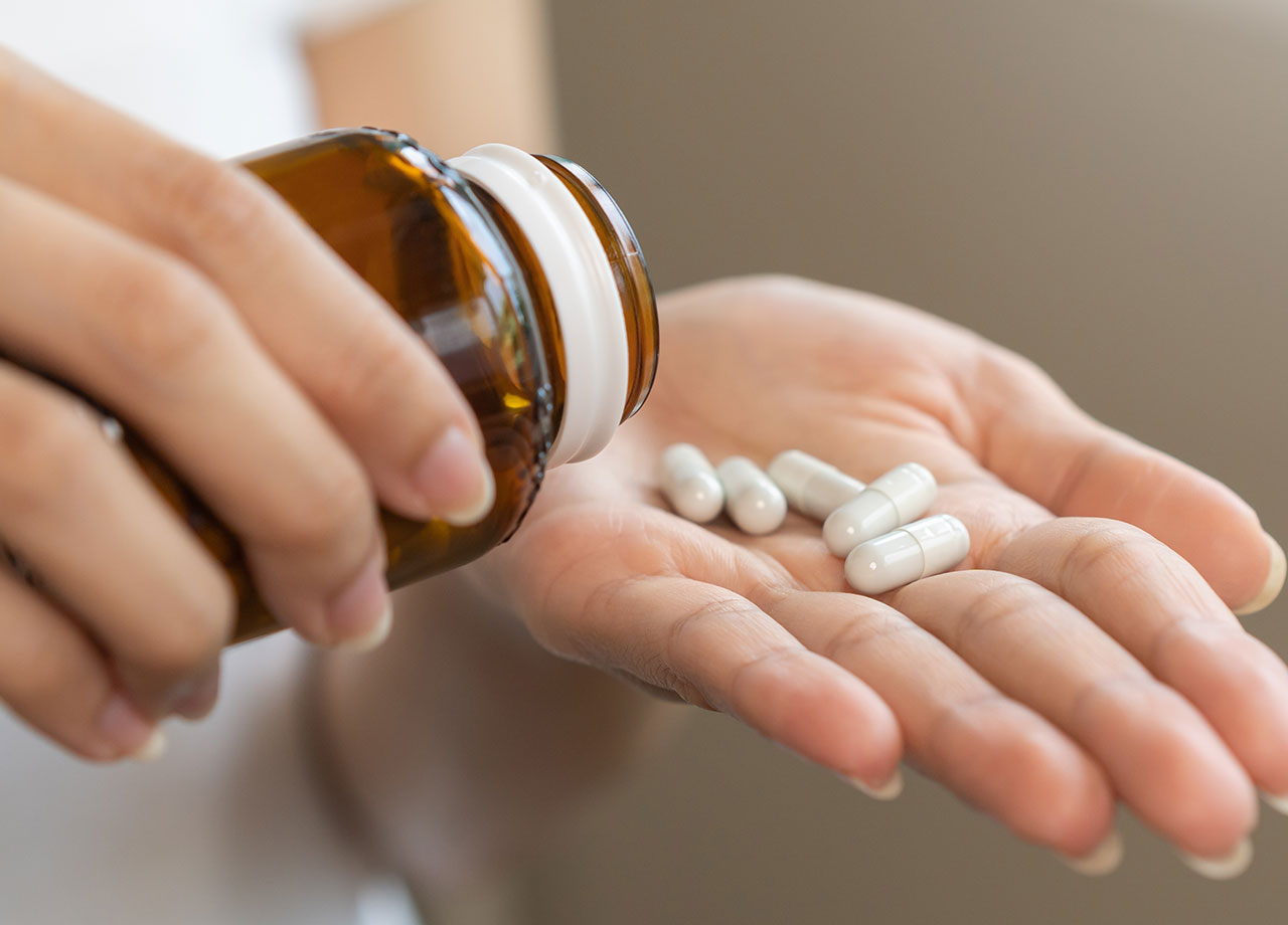 woman pouring out l proline pills