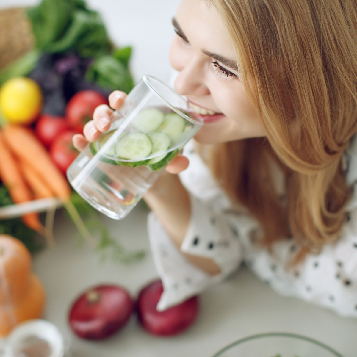 woman drinking water with cucumbers