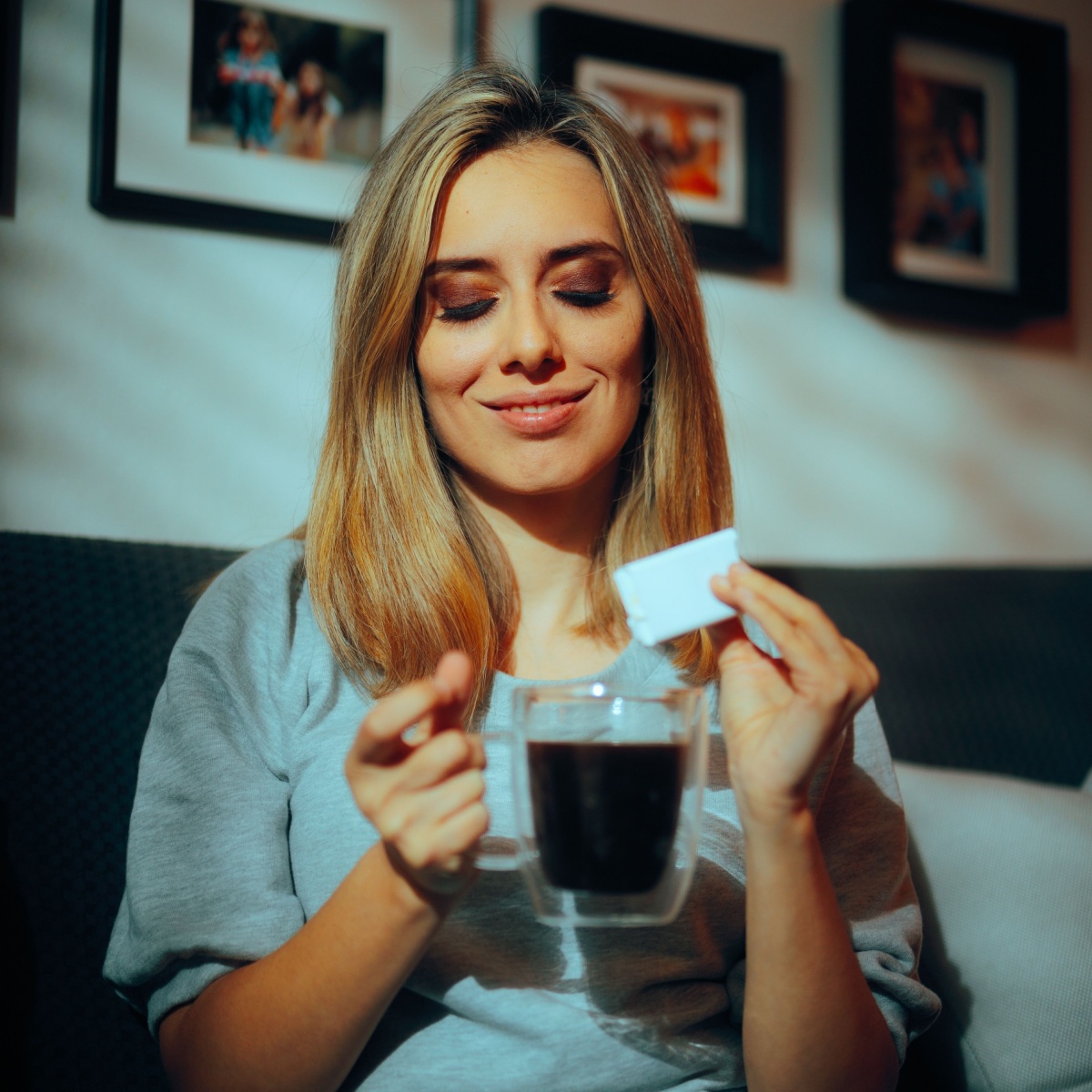 woman adding artificial sweetener in cup