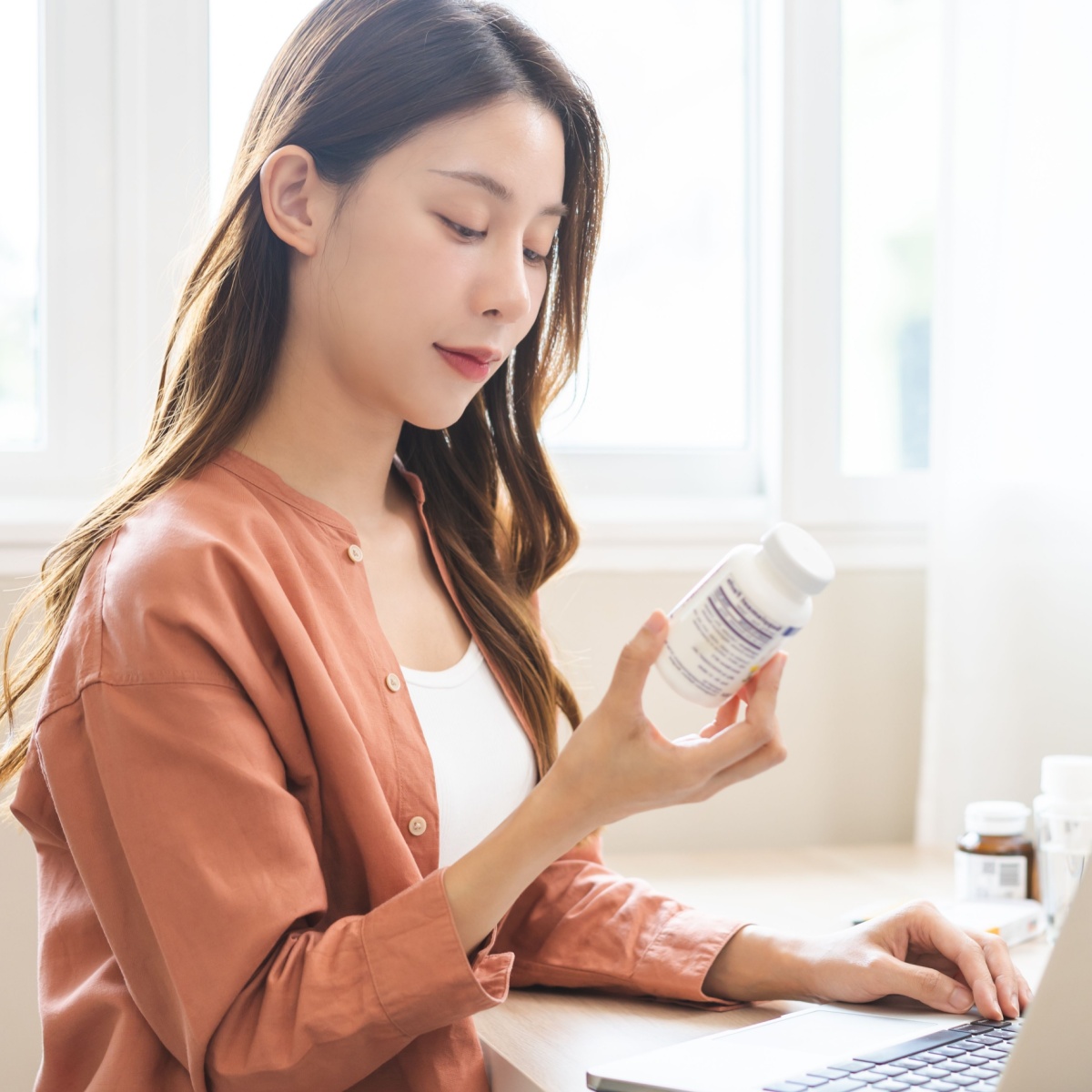 woman looking at bottle of pills