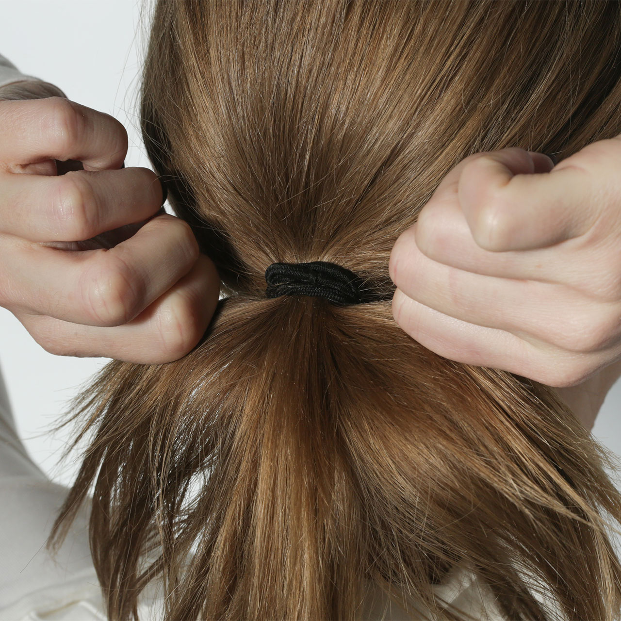 woman-pulling-hair-tight-ponytail