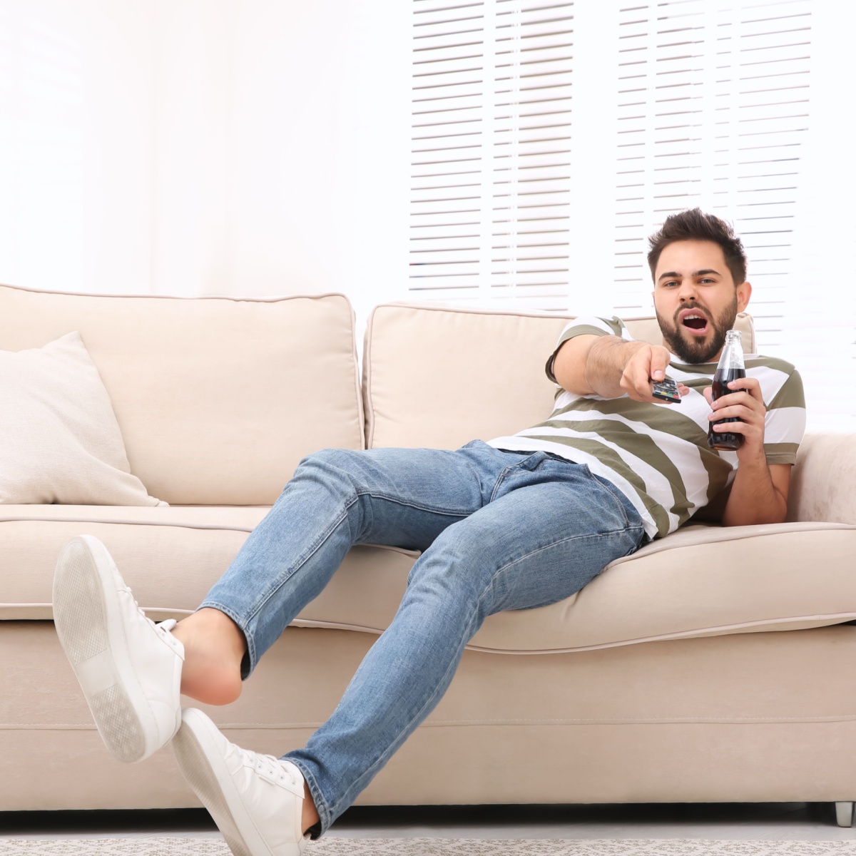 man sitting on couch playing video games