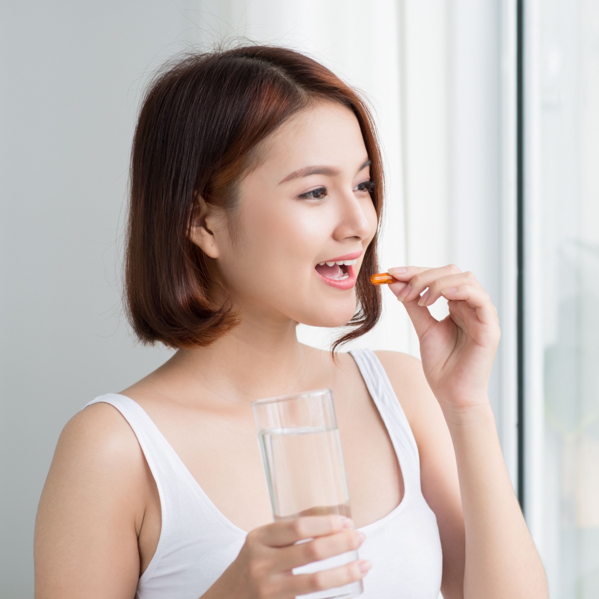 woman taking vitamin e pill