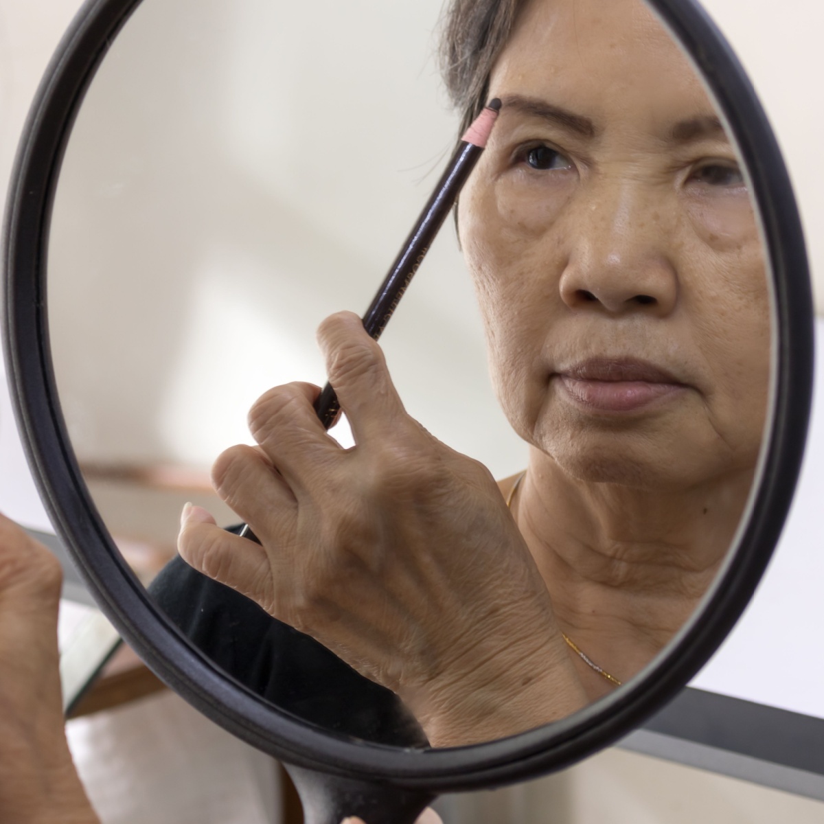 older asian lady filling in brows