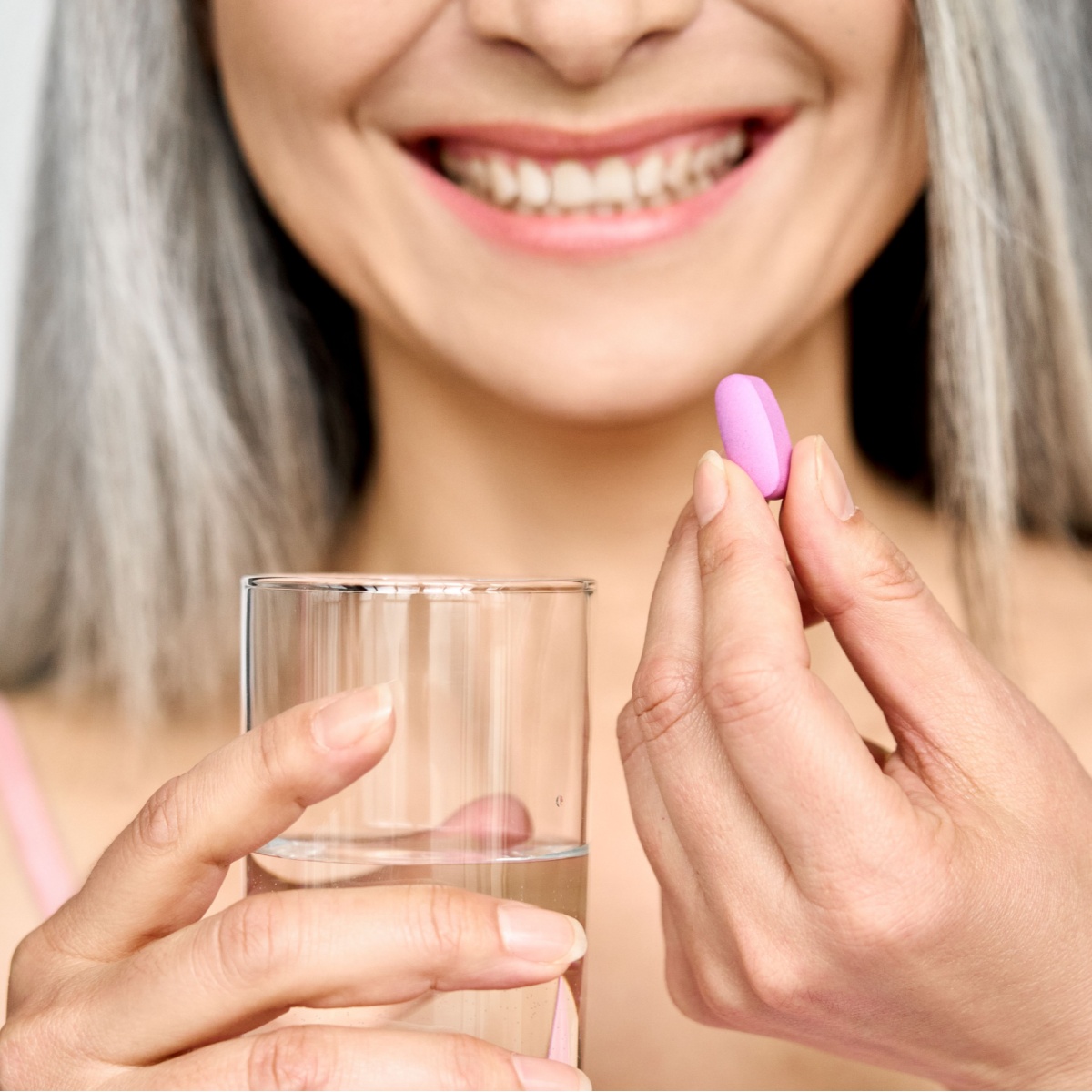 older woman taking supplement