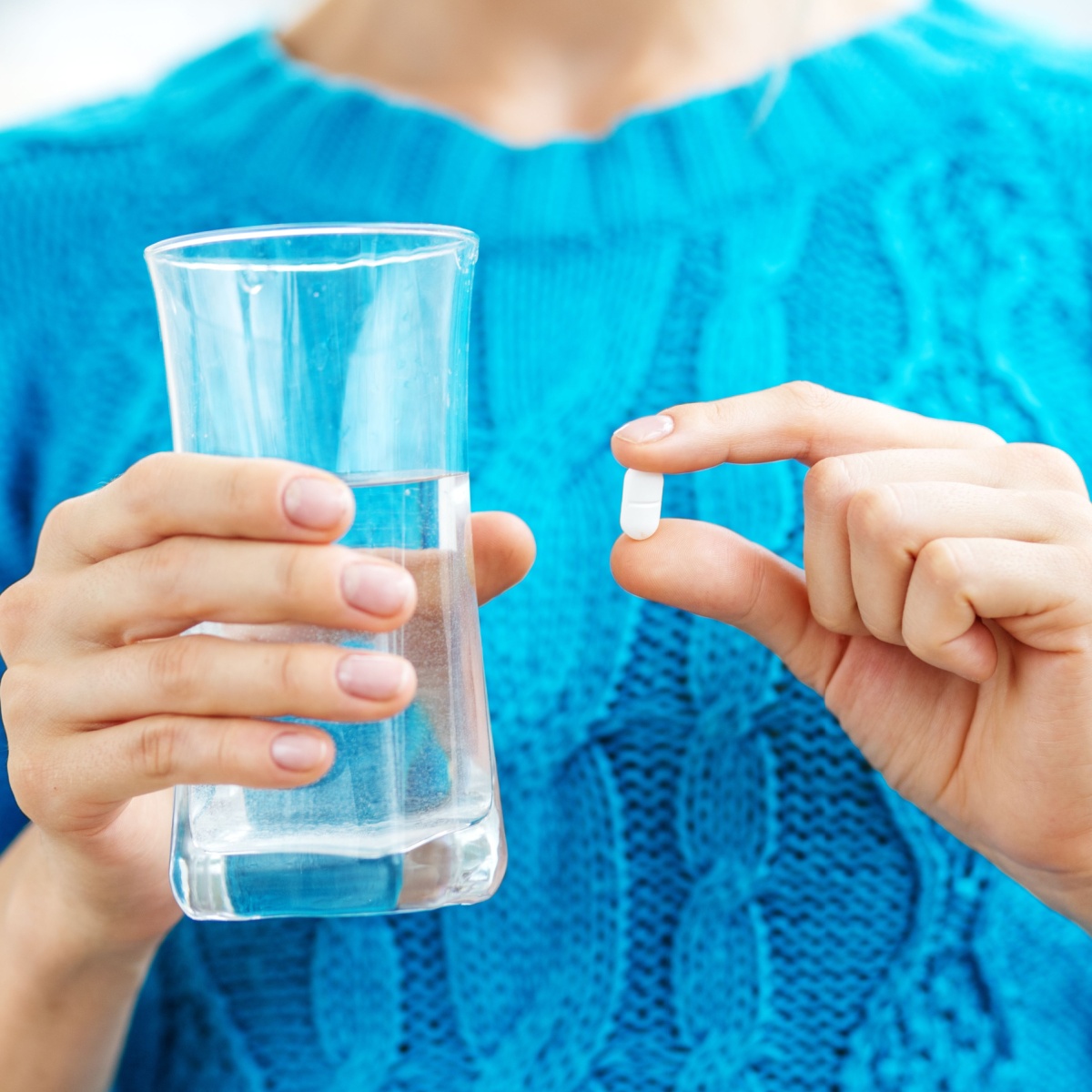 woman holding water and supplement