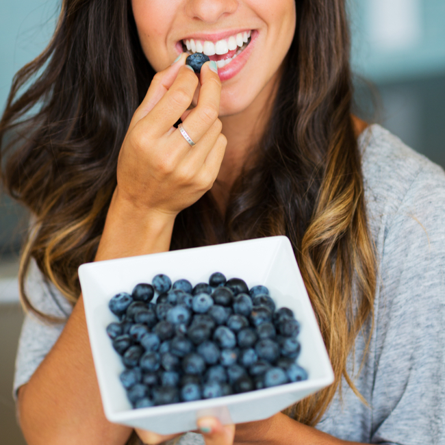 woman eating blueberry snack