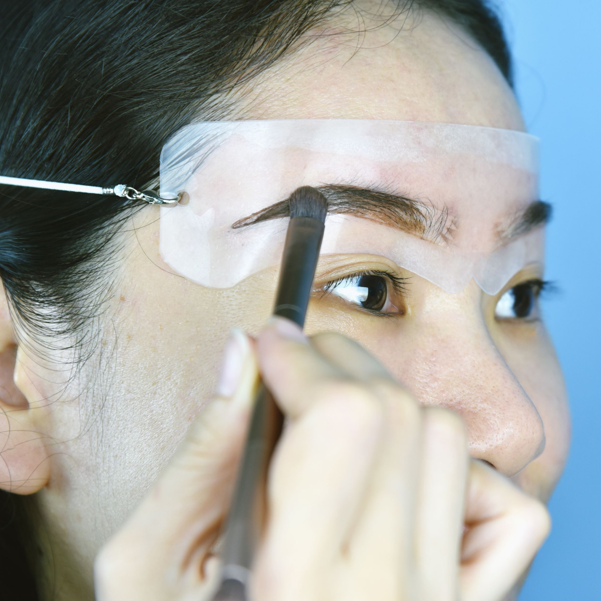 woman using eyebrow stencil