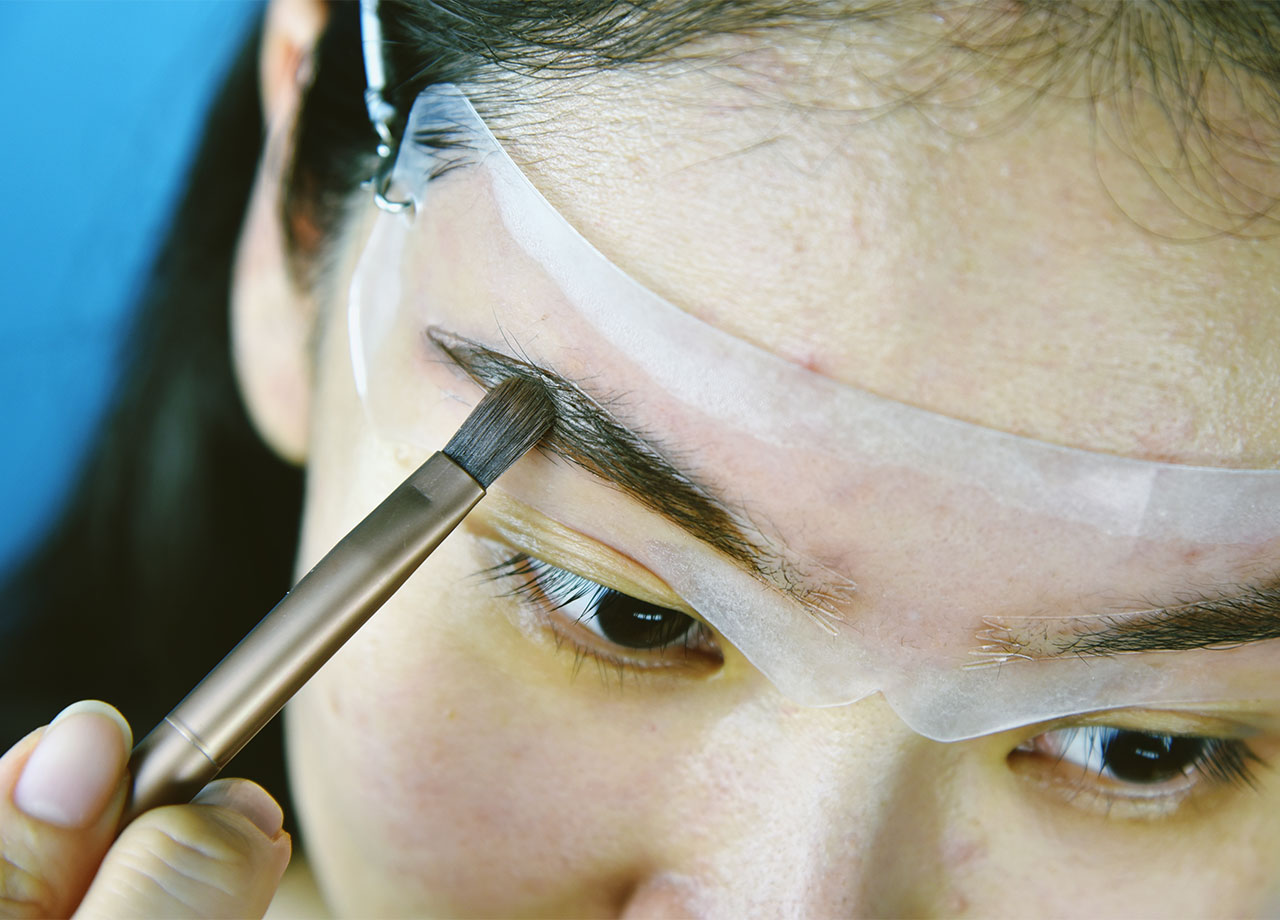 woman-using-eyebrow-stencil