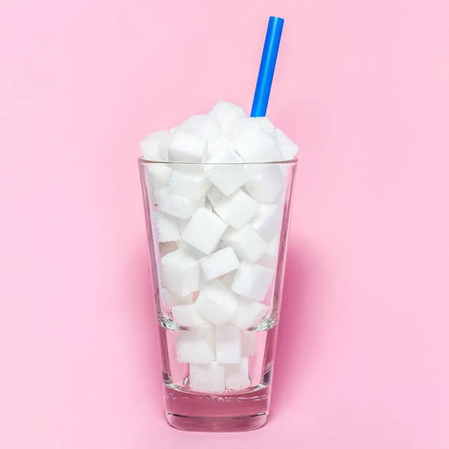 sugar cubes in a glass with a straw