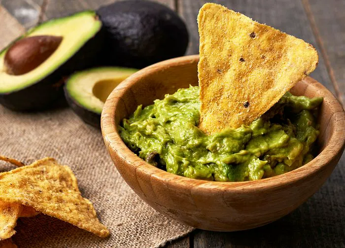Bowl of guacamole and a tortilla chip