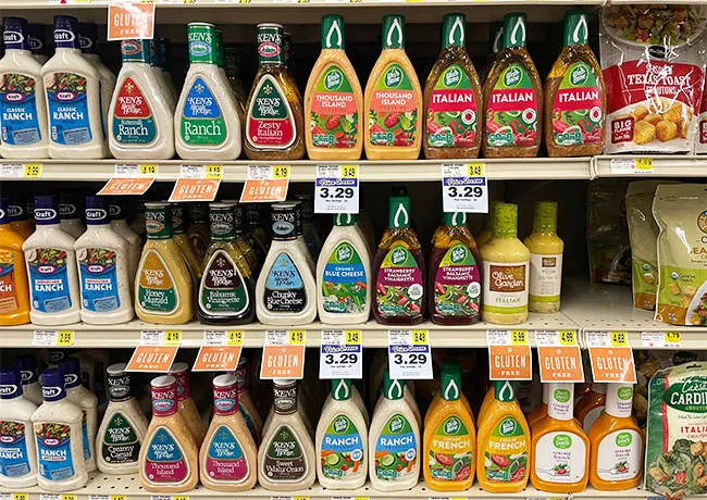 Various bottles of salad dressing on a kitchen countertop.