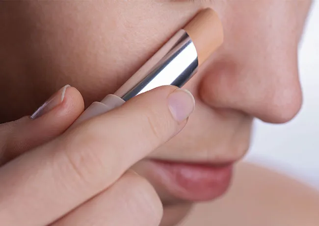 woman-applying-concealer-stick