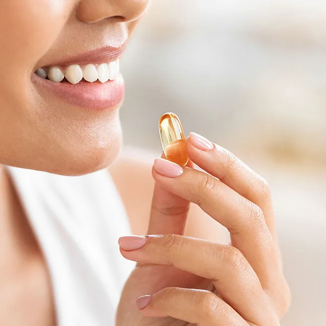"Woman taking a gel vitamin"